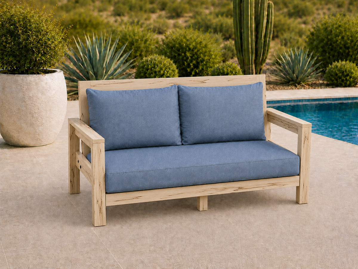 Classic Loveseat in Ambrosia Maple with Matte Clear finish and blue cushions on a desert patio.