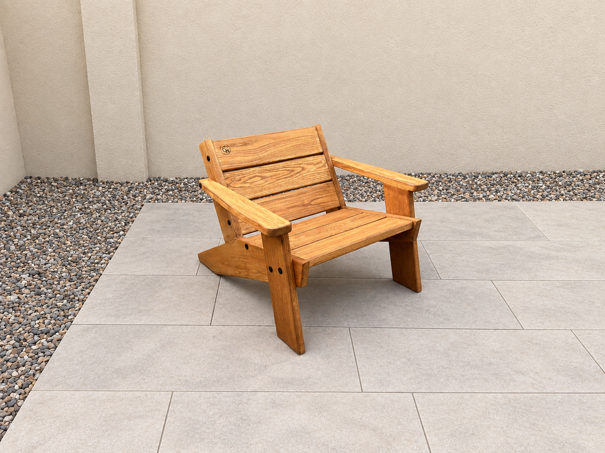 Opposite-angle view of the Low Boy Adirondack Chair in Red Oak with Canyon Honey finish, with an edited clean patio background.