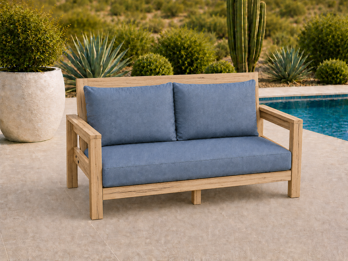Classic Loveseat in Ambrosia Maple with Natural Satin finish and blue cushions on a desert patio.