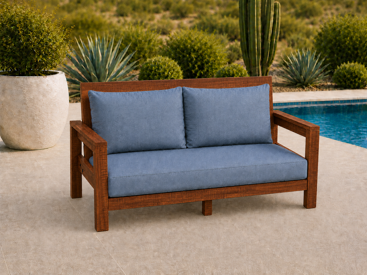 Classic Loveseat in Sapele Ribbon with Satin Oil finish and blue cushions on a desert patio.
