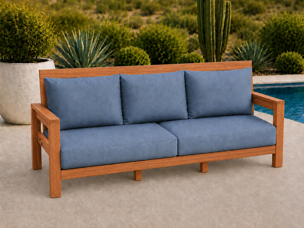 Classic Sofa in African Mahogany with Light Honey finish and blue cushions on a desert patio.