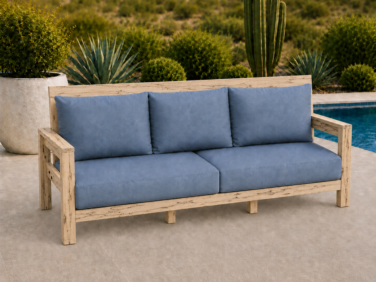 Classic Sofa in Ambrosia Maple with Matte Clear finish and blue cushions on a desert patio.